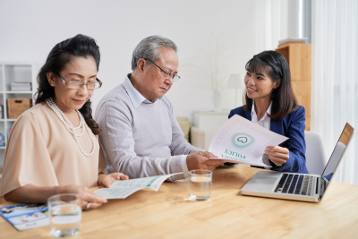 couple reading insurance policy documents with a female manager