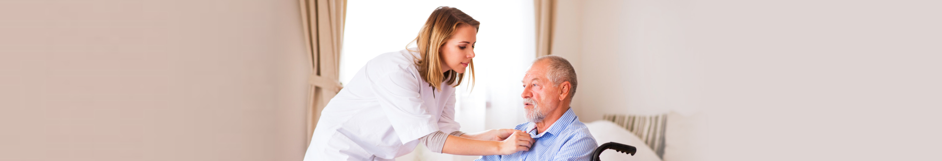caregiver fixing senior man's clothes